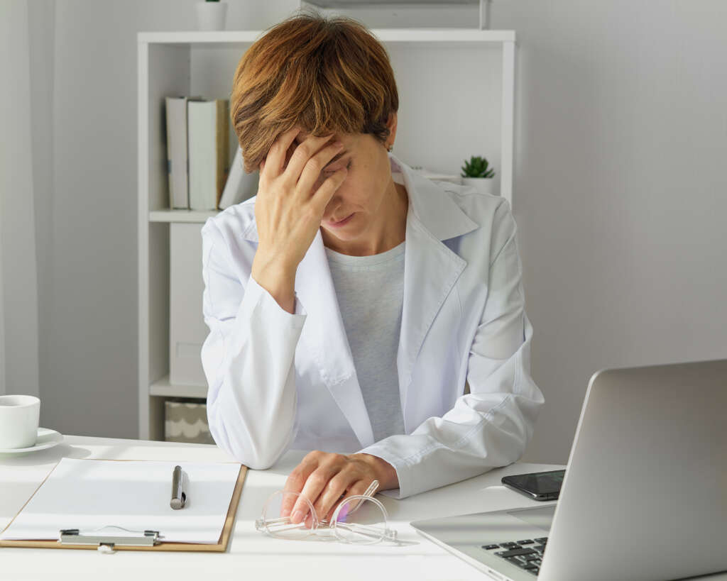 A stressed physiotherapist at work in the NHS as part of an article describing how online physiotherapy services are helping the NHS