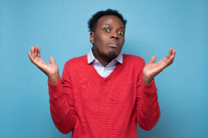 Young african american man gesturing do not know sign with confused expression. Isolated on blue background
