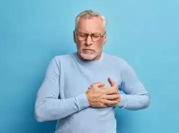 Blue background with a Senior man in spectacles presses hand to chest implying heart attack. Part of an article on future proofing your health