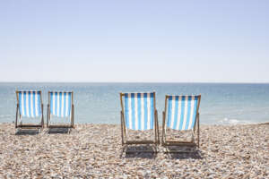UK, Brighton, Deckchairs on beach sunny day