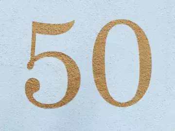 number 50 fifty in gold paint on blue wall.