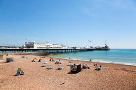Sunny day in brighton showing the beach and holiday makers.